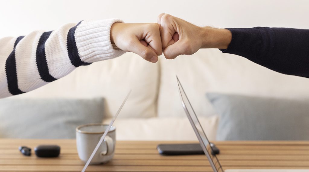 Des personnes se tapent le poing en signe de complicité