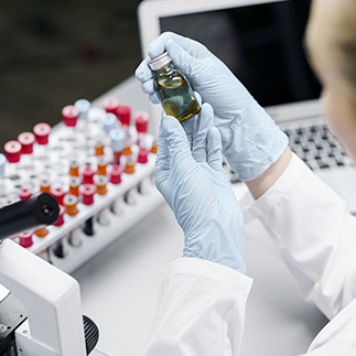 Une laborantine inspecte un flacon d'analyses
